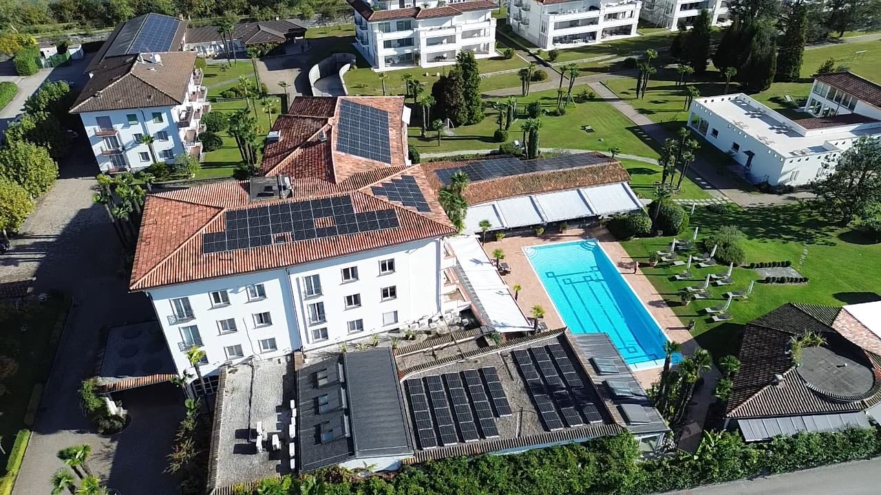 Veduta aerea del Park Hotel Delta: moduli fotovoltaici sui tetti dei corpi dell’albergo, con piscina e parco